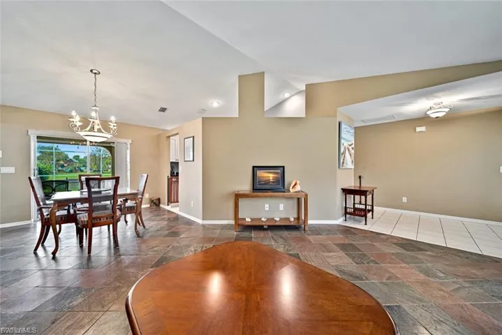 Dining area featuring stone tile flooring and vaulted ceiling