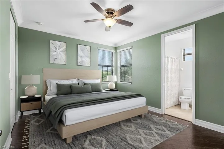 Bedroom with crown molding, ceiling fan, dark wood-type flooring, connected bathroom, and a textured wall