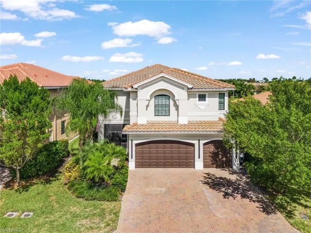 Mediterranean / spanish home featuring an attached garage, a tile roof, decorative driveway, and stucco siding