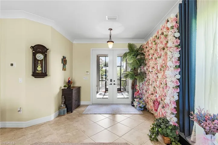 Foyer featuring french doors, ornamental molding, and tile patterned flooring