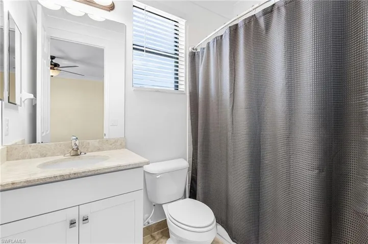 Bathroom with a shower with shower curtain, vanity, and ceiling fan
