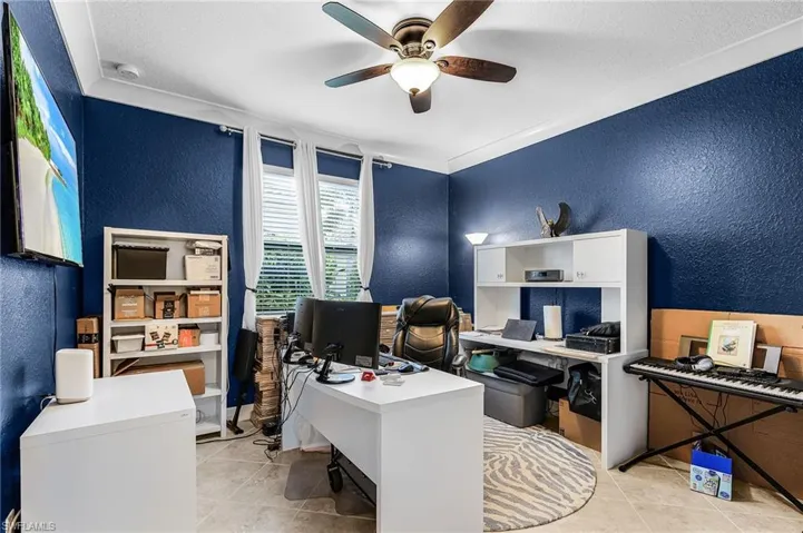 Office with a textured wall, light tile patterned floors, a ceiling fan, and a textured ceiling