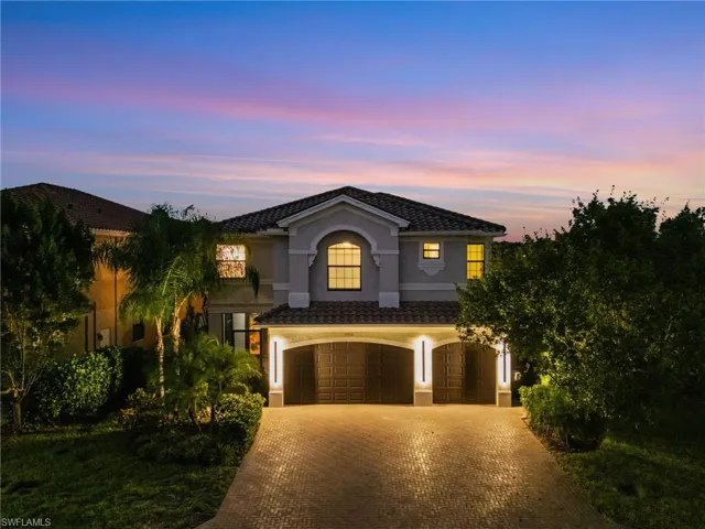 View of front of property with an attached garage, stucco siding, and driveway