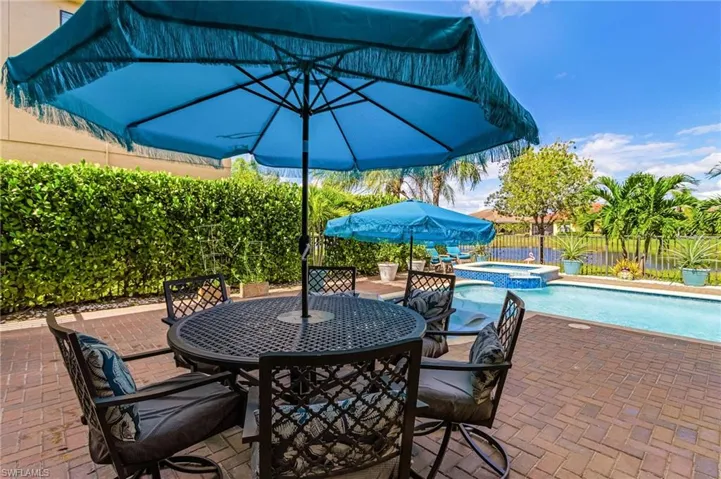Fenced backyard with outdoor dining area, a pool with connected hot tub, and a patio