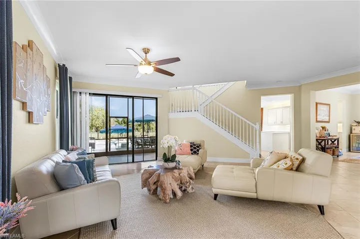 Living area with ornamental molding, ceiling fan, and tile patterned floors