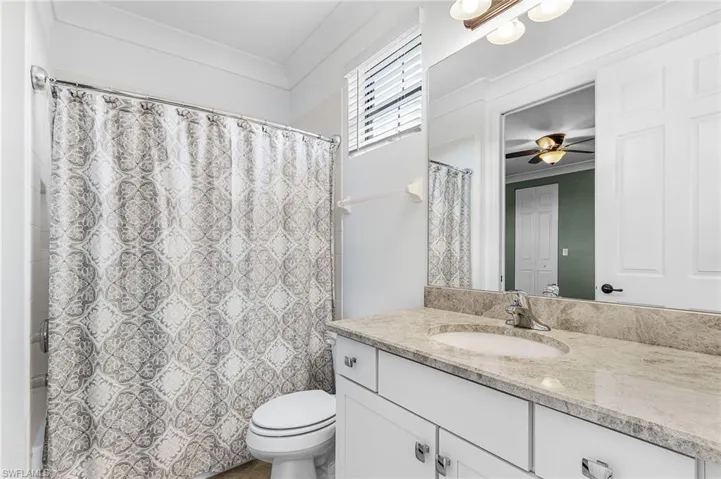 Full bath with vanity and a ceiling fan