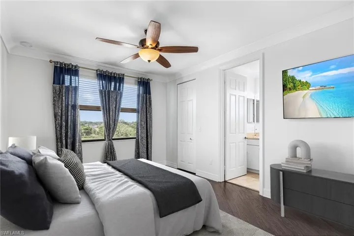 Bedroom featuring wood finished floors, ornamental molding, ceiling fan, a closet, and ensuite bath