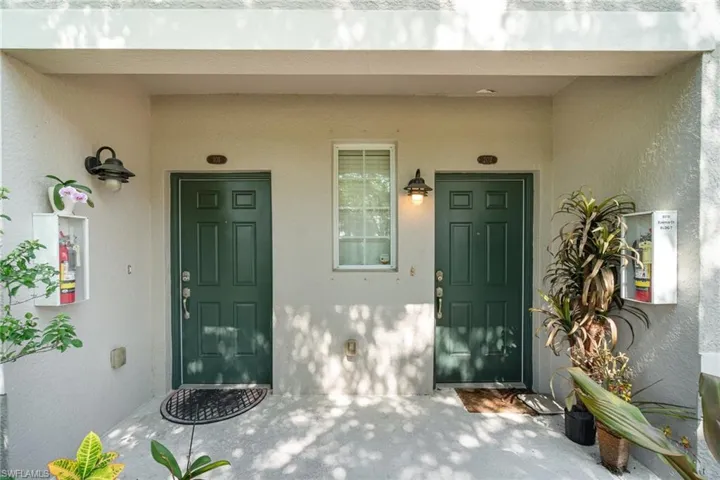 View of exterior entry featuring stucco siding and a porch