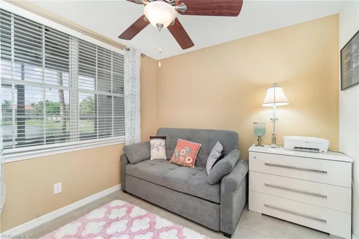 Sitting room featuring light tile patterned floors, a ceiling fan, and baseboards