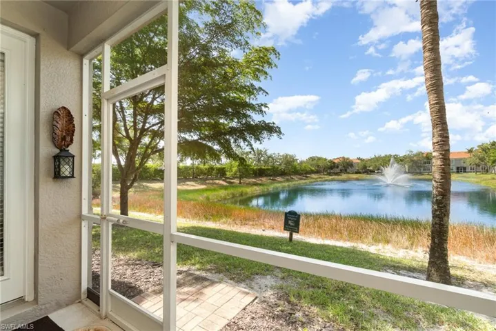 Unfurnished sunroom featuring a water view, a textured wall, and healthy amount of natural light
