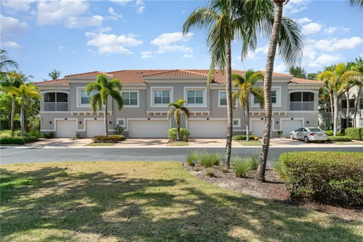 Townhome / multi-family property with a tiled roof, a garage, and stucco siding