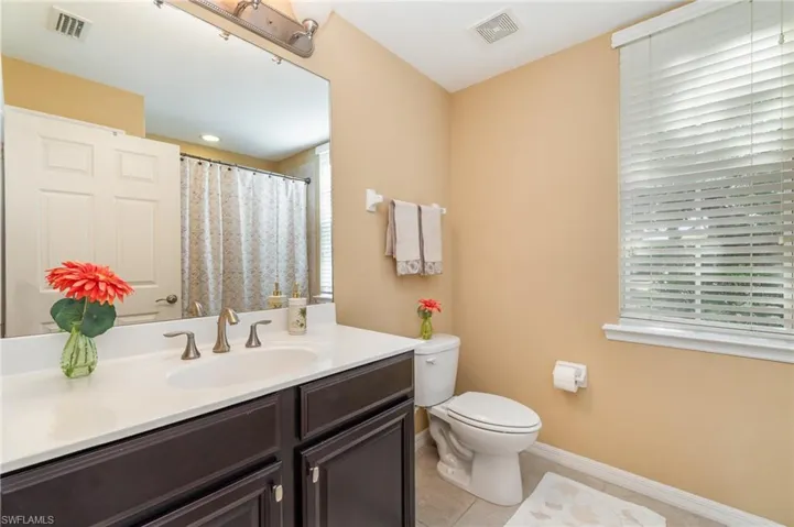 Bathroom with vanity, toilet, tile patterned flooring, and baseboards