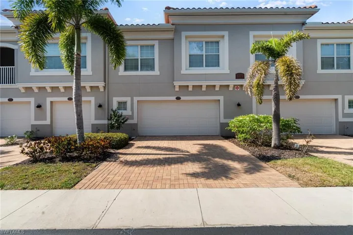 Townhome / multi-family property featuring an attached garage, stucco siding, driveway, and a tile roof