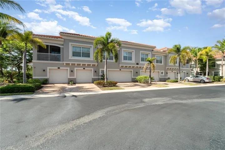 Multi unit property with a tile roof, a garage, and stucco siding