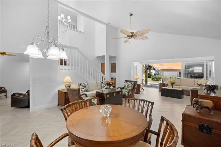 Dining room with a ceiling fan, hanging lights, lofted ceiling, and parquet floors