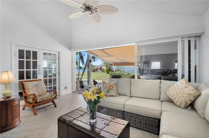 Sunroom / solarium with a ceiling fan, a patio, an outdoor hangout area, and french doors