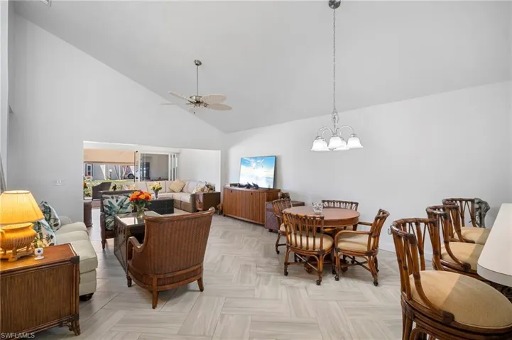 Living area with ceiling fan, lofted ceiling, and suspended lighting