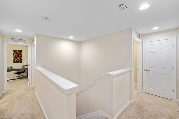 Hallway to linen closet straight ahead and laundry room to the left with a full-size washer and dryer