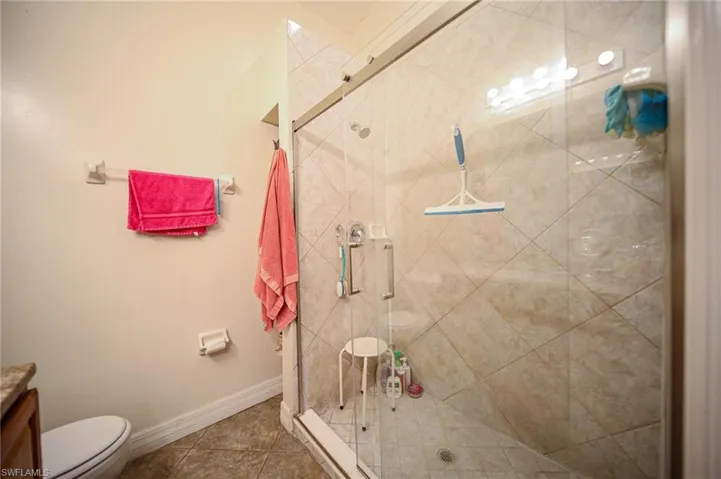 Bathroom with a shower stall, vanity, and tile patterned floors