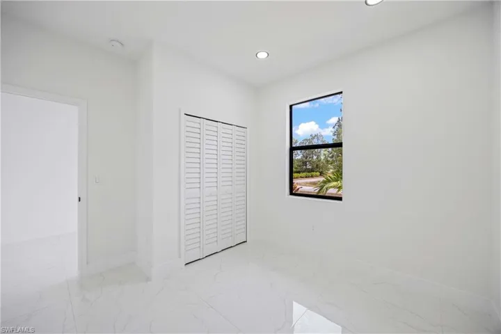 Unfurnished bedroom featuring light marble finish flooring, baseboards, recessed lighting, and a closet
