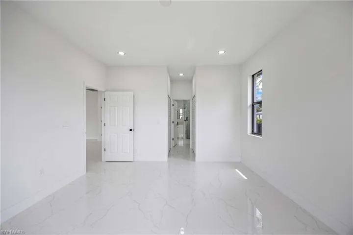 Spare room with baseboards, light marble finish flooring, and recessed lighting