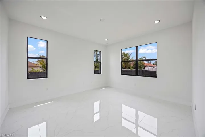 Empty room featuring marble tiled flooring, recessed lighting, and baseboards