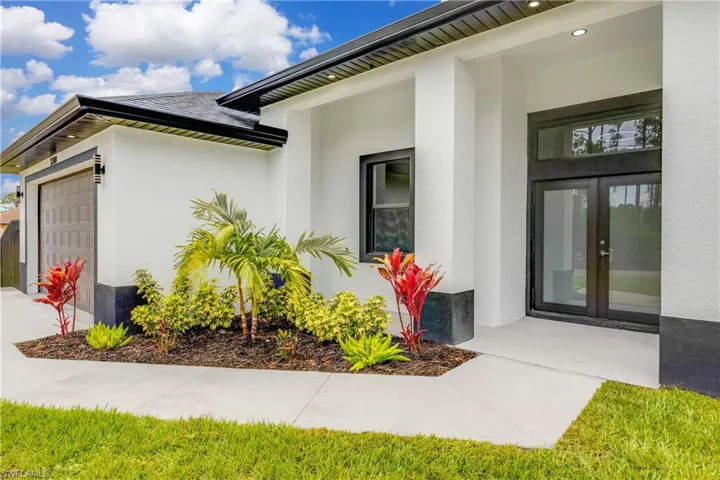 Entrance to property featuring french doors, a garage, and stucco siding