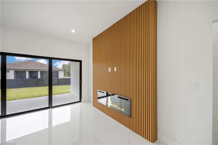 Unfurnished living room with marble tiled flooring and recessed lighting