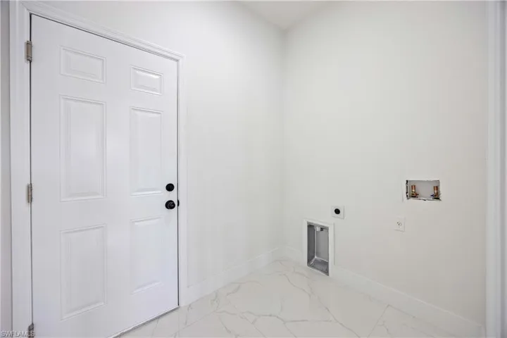 Laundry area with electric dryer hookup, light marble finish floors, hookup for a washing machine, and baseboards