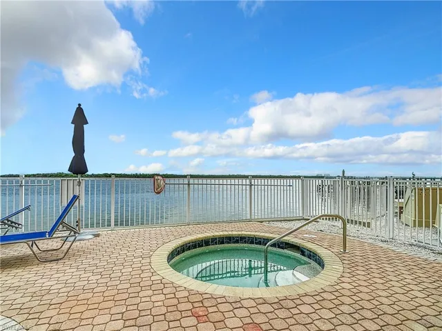 View of swimming pool featuring a community hot tub and a patio