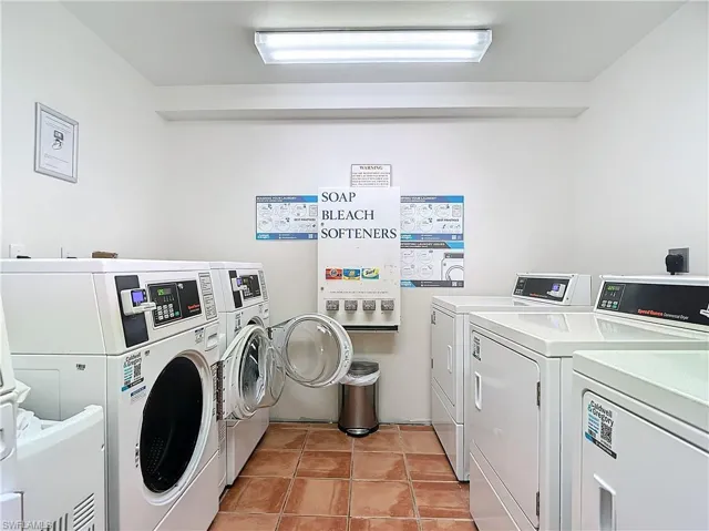 Clothes washing area with washer and dryer and light tile patterned floors
