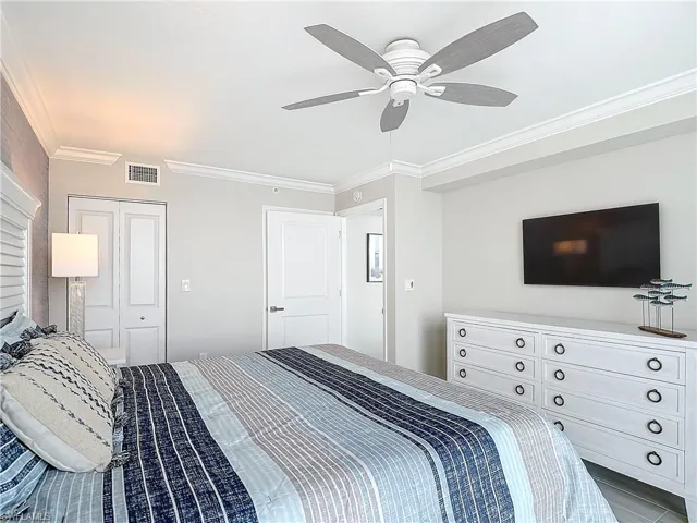 Bedroom featuring a closet,a safe, owners closet, ceiling fan, and crown molding