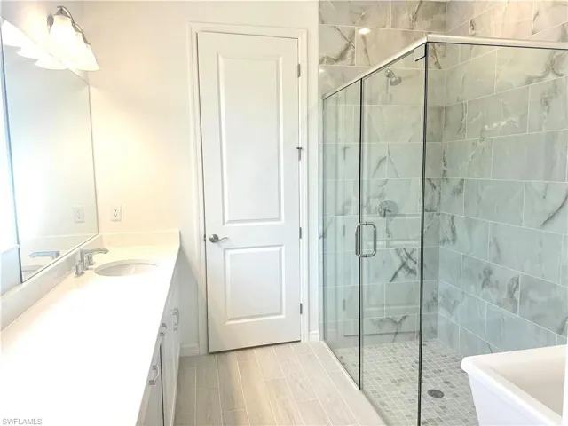 Primary bathroom with luxe, walk-in shower and free-standing Kohler bathtub