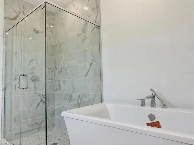 Primary bathroom with luxe, walk-in shower and free-standing Kohler bathtub
