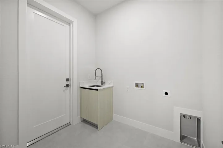 Laundry area with electric dryer hookup, hookup for a washing machine, and cabinet space
