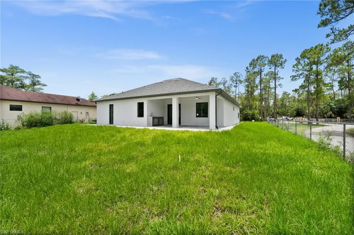 Rear view of house featuring ceiling fan, a patio, and stucco siding