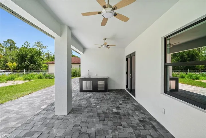View of patio with a ceiling fan and an outdoor kitchen