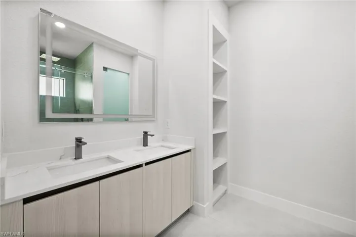 Full bath featuring double vanity and a shower with shower door