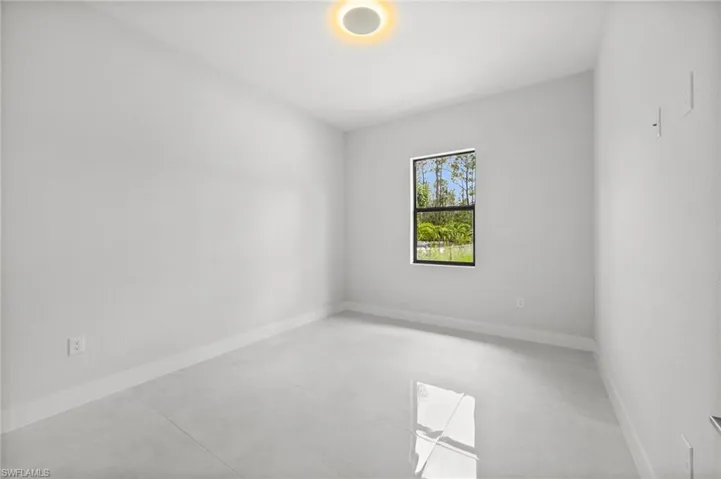 Empty room featuring baseboards and concrete floors