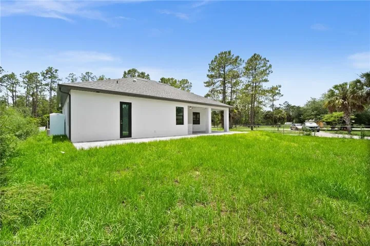 Rear view of house featuring stucco siding and a patio area