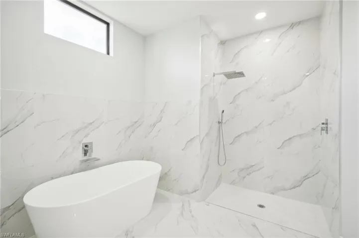 Bathroom with separate shower and tub and tile walls