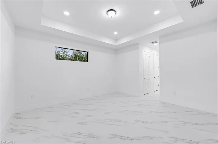 Unfurnished room featuring a raised ceiling