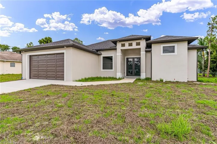 Prairie-style home with a garage and a front lawn