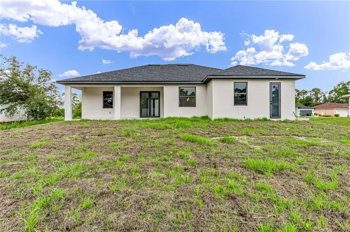 Back of property featuring a yard