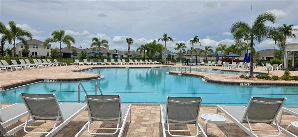 Expansive community pool with a curvilinear design and integrated sun shelf
