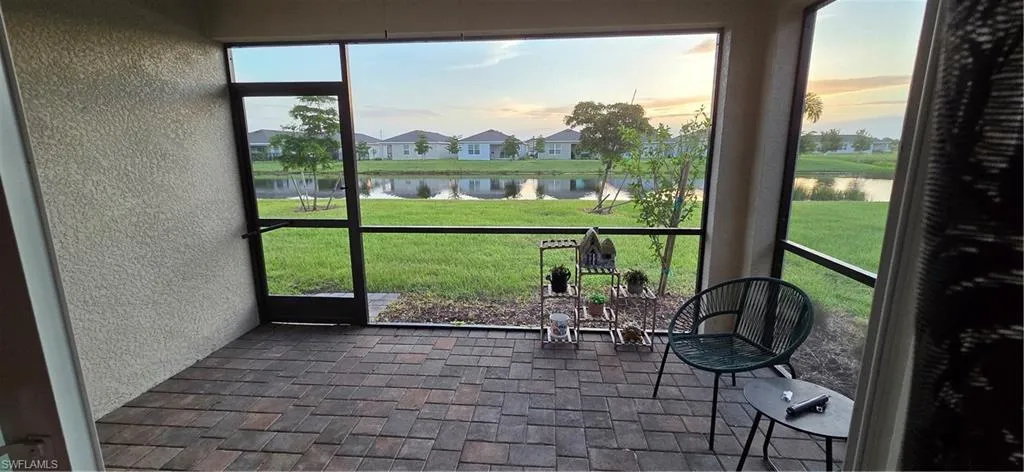 Screened lanai featuring brick paver flooring, textured exterior wall, and a full-height screen enclosure