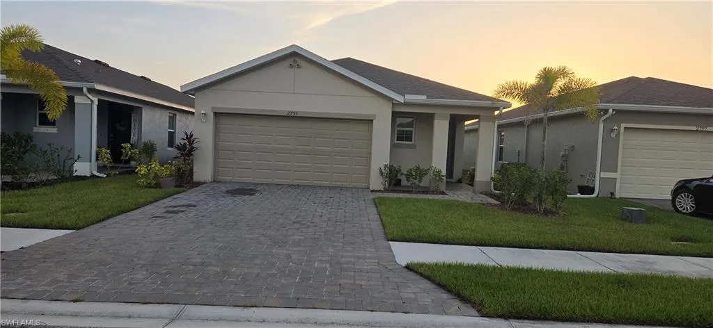 Single-story residence featuring a neutral-toned stucco exterior, a gray shingle roof, and an integrated two-car garage with a panel door