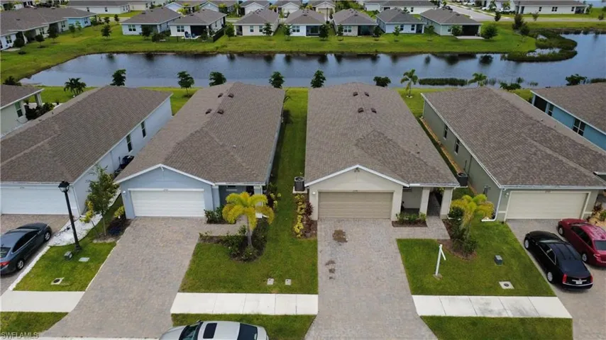Single-story residences featuring paver driveways, attached garages, landscaped front yards, and shingle roofs