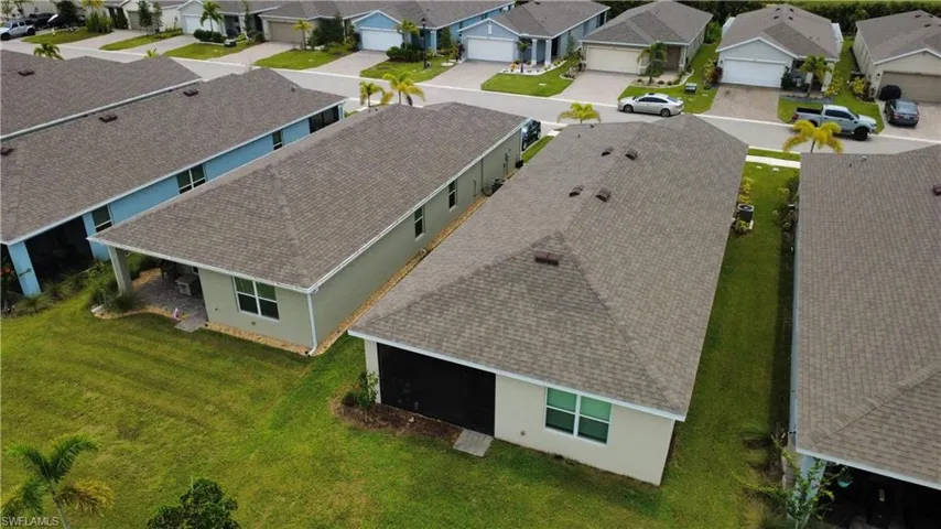 Residential backyard featuring a covered patio with paved flooring and a green lawn