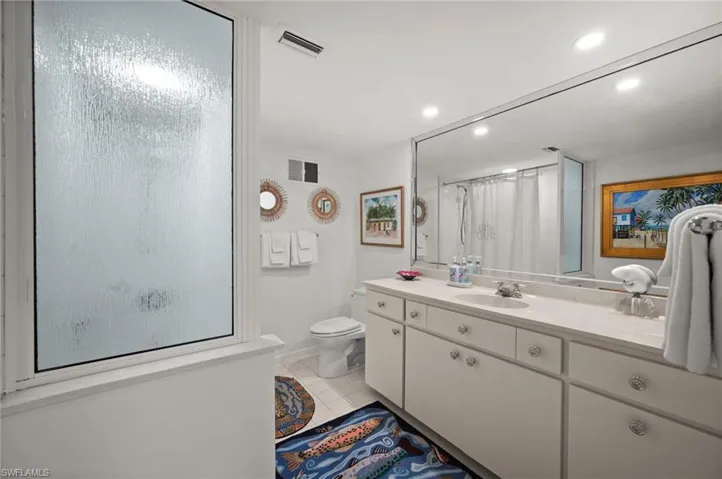 Guest bedroom 2's en-suite bathroom has a cast iron tub with shower, an oversized single sink vanity and mirror as well as a separate linen closet!